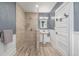 Modern bathroom featuring walk-in shower with tan tile, pedestal sink, and wainscoting at 13183 N 95Th St, Longmont, CO 80504
