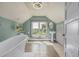 Bathroom features a clawfoot tub, pedestal sink, tiled floors, and scenic window view at 13183 N 95Th St, Longmont, CO 80504