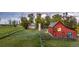 Charming home with a well-maintained yard, accented by a red barn and mature trees, plus a wooden fence at 13183 N 95Th St, Longmont, CO 80504