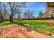 Beautiful backyard features a well-maintained lawn, mature trees, and a charming bird bath on a wooden deck at 1705 Stonehenge Dr, Lafayette, CO 80026