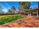 Well-maintained deck leading to a spacious backyard with mature trees and lush green grass at 1705 Stonehenge Dr, Lafayette, CO 80026