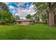 Spacious backyard with green grass, mature trees, and a deck at 1705 Stonehenge Dr, Lafayette, CO 80026