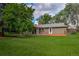 Large backyard featuring mature trees, a lush green lawn, and a deck at 1705 Stonehenge Dr, Lafayette, CO 80026