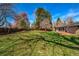 Large backyard with lush green lawn and mature trees providing shade and privacy at 1705 Stonehenge Dr, Lafayette, CO 80026