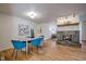 Inviting dining room with hardwood floors, teal upholstered chairs, and seamless flow to kitchen and living areas at 1705 Stonehenge Dr, Lafayette, CO 80026