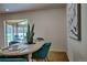 Dining area showcasing stylish teal chairs, hardwood floors and a sunroom visible in background at 1705 Stonehenge Dr, Lafayette, CO 80026
