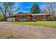 Charming brick home with a well-maintained lawn and bright red window shutters at 1705 Stonehenge Dr, Lafayette, CO 80026