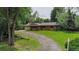 Charming ranch-style home with brick facade, complemented by a well-manicured lawn and tree-lined driveway at 1705 Stonehenge Dr, Lafayette, CO 80026