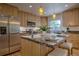 Sunlit kitchen featuring stainless appliances, wood cabinets, granite countertops and a large island with barstool seating at 1705 Stonehenge Dr, Lafayette, CO 80026