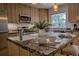 Spacious kitchen with stainless steel appliances, granite counters, wood cabinets and a central island with bar seating at 1705 Stonehenge Dr, Lafayette, CO 80026