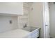 Functional laundry area with deep sink, white cabinets, and wire shelving at 1705 Stonehenge Dr, Lafayette, CO 80026