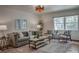 Cozy living room featuring a plush gray sofa, patterned rug, and window with natural light at 1705 Stonehenge Dr, Lafayette, CO 80026
