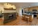 Open concept kitchen and living space with fireplace, hardwood floors, and stainless steel appliances at 1705 Stonehenge Dr, Lafayette, CO 80026