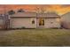 Backyard view with a grassy area, bare trees, and the exterior of the home with patio access at 11623 W Hornsilver Mtn, Littleton, CO 80127