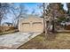 House exterior featuring a two-car garage, a well-maintained lawn and mature trees surrounding the property at 11623 W Hornsilver Mtn, Littleton, CO 80127