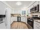 Well-lit kitchen features white cabinets, stainless steel appliances, and granite countertops at 11623 W Hornsilver Mtn, Littleton, CO 80127