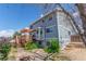 Back of house with deck, bay window, landscaped backyard with mature trees and stone patio at 4022 S Kalispell St, Aurora, CO 80013