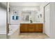 Bathroom with double sinks, wood cabinets, and a bathtub at 1894 S Marshall Cir, Lakewood, CO 80232