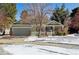 Green two-story house with a snow covered front yard and a red front door at 1894 S Marshall Cir, Lakewood, CO 80232