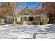 Ranch style home with snow-covered lawn and landscaping at 1894 S Marshall Cir, Lakewood, CO 80232