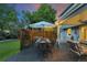 Back patio with an outdoor dining table, chairs, umbrella, and landscaping at 3765 E Easter Dr, Centennial, CO 80122