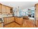 Open-concept kitchen with wood cabinets, stainless appliances, hardwood floors, and breakfast bar at 3765 E Easter Dr, Centennial, CO 80122