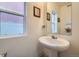 Bathroom featuring a pedestal sink and framed mirrors with natural lighting at 5541 Killarney Ct, Denver, CO 80249
