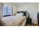 Cozy bedroom featuring a plush bed, dark wood furniture, and a bright window at 5541 Killarney Ct, Denver, CO 80249