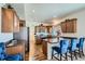 Well-lit kitchen with wood cabinets, stainless steel appliances, and breakfast bar with blue chairs at 5541 Killarney Ct, Denver, CO 80249