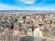 Expansive aerial view of a suburban neighborhood with mountains and lake in the background at 9905 Foxhill Cir, Highlands Ranch, CO 80129