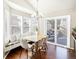 Sunlit dining area with a wooden table, comfortable chairs, and a built-in bench with large windows at 9905 Foxhill Cir, Highlands Ranch, CO 80129