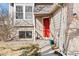 Welcoming front entrance with a bright red door, brick accents, and neatly landscaped yard at 9905 Foxhill Cir, Highlands Ranch, CO 80129