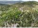Aerial view of property nestled among trees in a lush, mountainous landscape at 32171 Lodgepole Dr, Evergreen, CO 80439