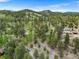 Aerial view of a home surrounded by mature trees and rolling hills at 32171 Lodgepole Dr, Evergreen, CO 80439