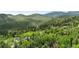 Beautiful aerial view of a home nestled among lush trees and rolling hills at 32171 Lodgepole Dr, Evergreen, CO 80439