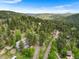 Aerial view of the property with a long driveway, nestled among trees with other houses nearby at 32171 Lodgepole Dr, Evergreen, CO 80439