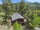 Breathtaking aerial view of a home surrounded by majestic pine trees and mountain scenery at 32171 Lodgepole Dr, Evergreen, CO 80439