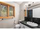 Well-lit bathroom featuring a large window with wood trim and a dark green countertop at 32171 Lodgepole Dr, Evergreen, CO 80439