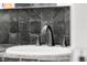 Close up of bathroom sink with dark tile and hardware at 32171 Lodgepole Dr, Evergreen, CO 80439