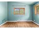 Bedroom featuring wood floors, baseboard heating, and a double hung window with wood trim at 32171 Lodgepole Dr, Evergreen, CO 80439