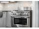 Close-up of a stainless steel range in a modern kitchen with gray cabinets at 32171 Lodgepole Dr, Evergreen, CO 80439
