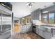 Open-concept kitchen featuring gray cabinetry, stainless appliances, and hardwood flooring at 32171 Lodgepole Dr, Evergreen, CO 80439