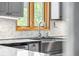 Kitchen area showcasing a stainless steel sink, granite countertops, and tiled backsplash at 32171 Lodgepole Dr, Evergreen, CO 80439