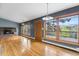 Bright living room with a stone fireplace, wood floors, and natural light from many windows at 32171 Lodgepole Dr, Evergreen, CO 80439