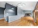 Open living room featuring wood floors, rock fireplace, and lots of natural light at 32171 Lodgepole Dr, Evergreen, CO 80439