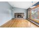Cozy living room featuring a stone fireplace, hardwood floors, and large windows with natural light at 32171 Lodgepole Dr, Evergreen, CO 80439