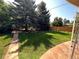 Well-maintained backyard featuring healthy green grass and mature trees at 6176 S Adams Dr, Centennial, CO 80121