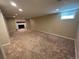 Spacious basement features plush carpeting, recessed lighting, and a cozy fireplace at 6176 S Adams Dr, Centennial, CO 80121
