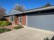 Attached two-car garage with modern gray door and brick exterior home with beautiful landscaping at 6176 S Adams Dr, Centennial, CO 80121