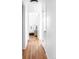 Hallway with hardwood floors and a glimpse into a bright bedroom at 6842 W Eldorado Pl, Lakewood, CO 80227